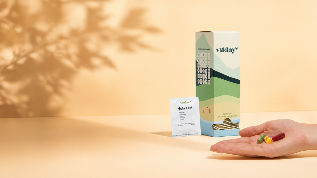Caja Vitday de 30 sobres, un sobre personalizado y una mano con las cápsulas del día